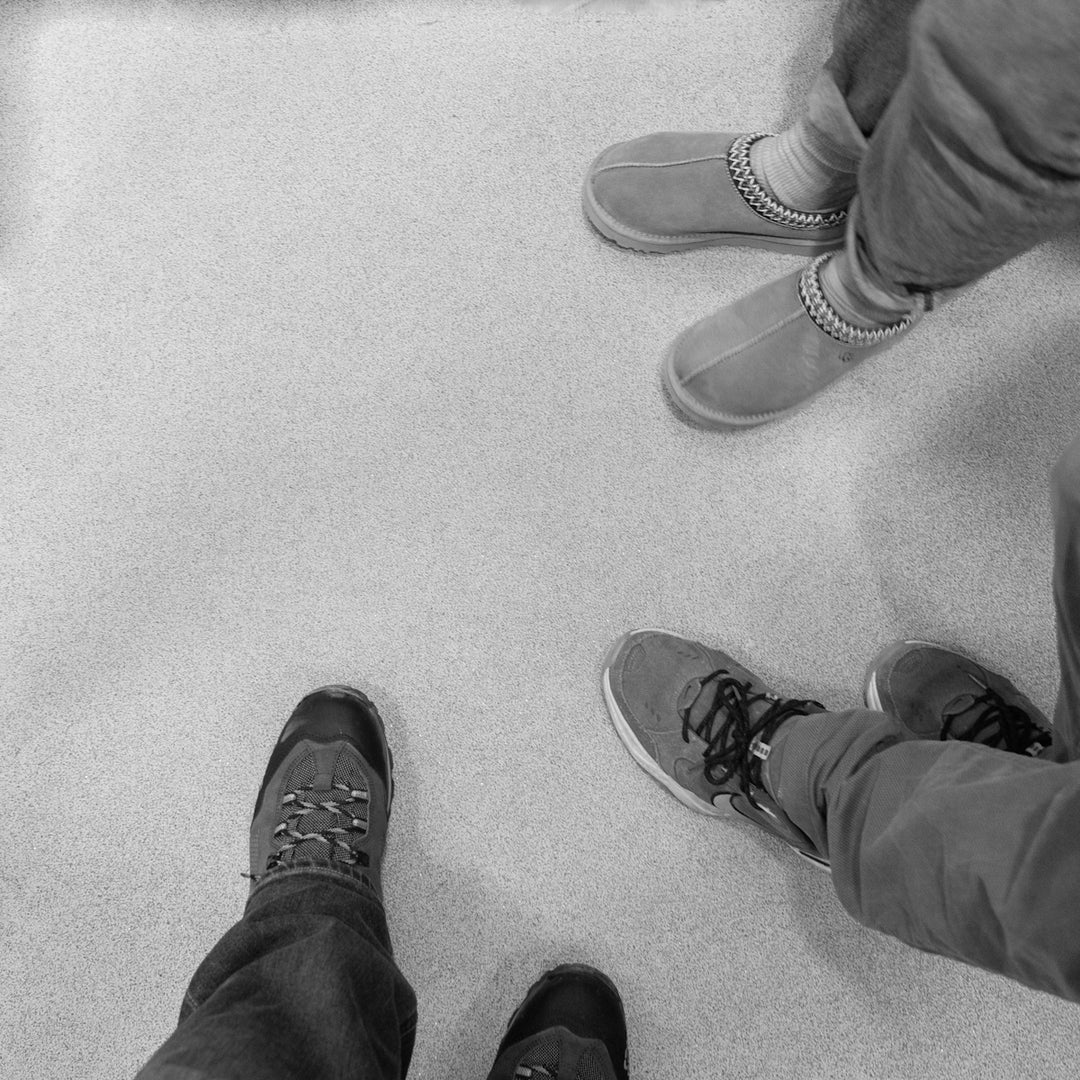 Four pairs of shoes on a light floor.